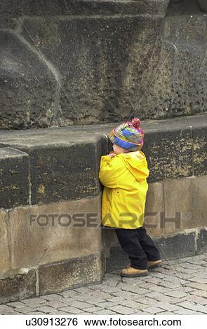 Young boy standing against a wall in Prague View Large Photo Image Stock Photograph - Young boy standing against a wall in Prague. Fotosearch