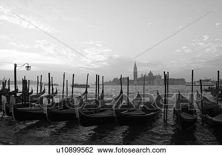 Stock Image - Array of gondolas docked at a canal in Venice, Italy. Fotosearch