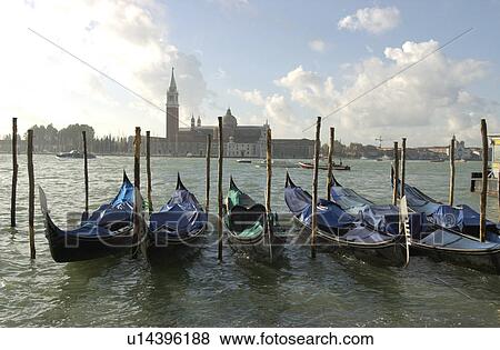 Array of gondolas docked at a canal in Venice, Italy View Large Photo Image Stock Photo - Array of gondolas docked at a canal in Venice, Italy. Fotosearch