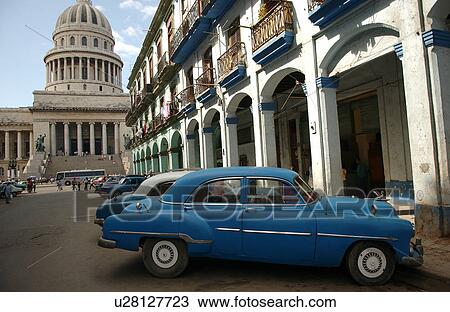Stock Image - Antique cars parked in front of the capitol building, Havana, Cuba. Fotosearch