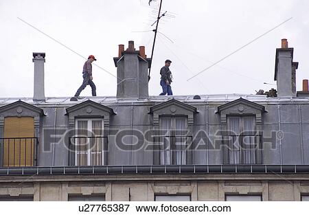 Stock Photo - People walking on building roof tops in Paris, France. Fotosearch