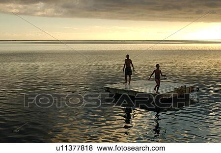 Stock Photo - A young couple on a raft in the sea. Fotosearch