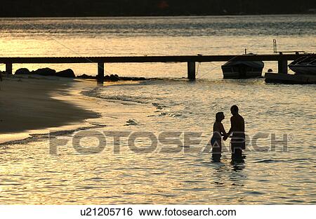 A young couple standing in water near a beach, Moorea, Tahiti, French Polynesia, South Pacific View Large Photo Image Stock Photograph - A young couple standing in water near a beach, Moorea, Tahiti, French Polynesia, South Pacific. Fotosearch