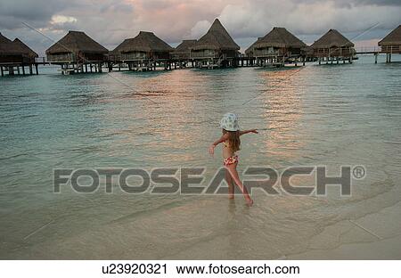 Stock Image - A young girl (6-8) on a beach. Fotosearch