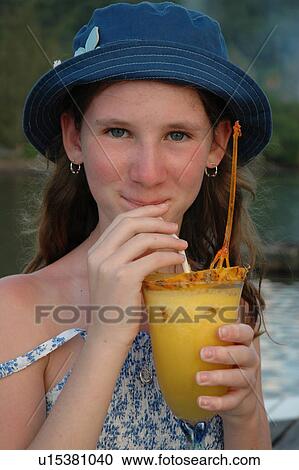 Stock Image - Portrait of a teenaged girl sipping a pineapple drink. Fotosearch