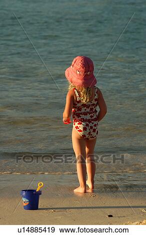 Rear of a young girl (6-8) on a beach View Large Photo Image Stock Photo - Rear of a young girl (6-8) on a beach. Fotosearch