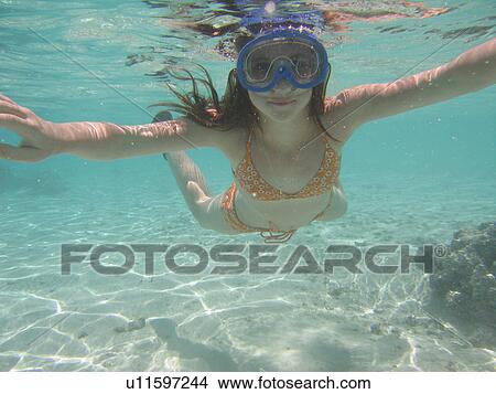Picture - Underwater view of a young woman scuba diving. Fotosearch