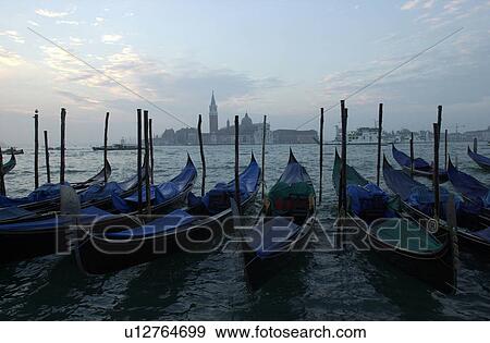 Array of gondolas docked at a canal in Venice, Italy View Large Photo Image Stock Photo - Array of gondolas docked at a canal in Venice, Italy. Fotosearch