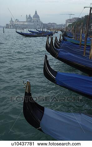 Stock Image - Array of gondolas docked at a canal in Venice, Italy. Fotosearch