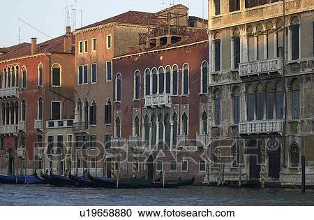 Stock Image - Gondolas docked near buildings in Venice, Italy. Fotosearch