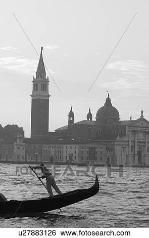 Oarsman driving a gondola in a canal in Venice, Italy View Large Photo Image Stock Photograph - Oarsman driving a gondola in a canal in Venice, Italy. Fotosearch