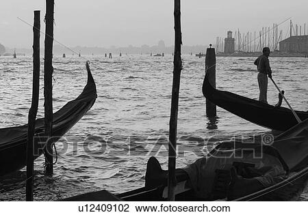 Oarsmen driving a gondola in Venice, Italy View Large Photo Image Stock Image - Oarsmen driving a gondola in Venice, Italy. Fotosearch