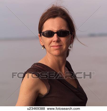 Stock Photo - Brunette woman wearing sunglasses. Fotosearch