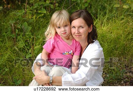 Portrait of a young mother holding her daughter View Large Photo Image Stock Image - Portrait of a young mother holding her daughter. Fotosearch