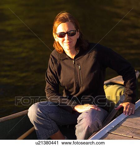 Portrait of a young woman sitting in a canoe View Large Photo Image Stock Image - Portrait of a young woman sitting in a canoe. Fotosearch