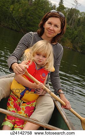 Young woman and her daughter paddling in a canoe View Large Photo Image Stock Photo - Young woman and her daughter paddling in a canoe. Fotosearch