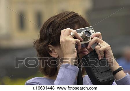 Stock Photo - Young woman clicking photograph in Prague. Fotosearch