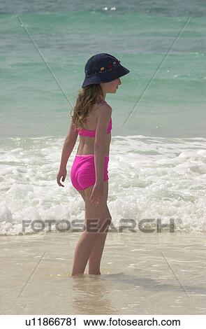 Stock Image - Young girl walking on the beach in Mexico. Fotosearch