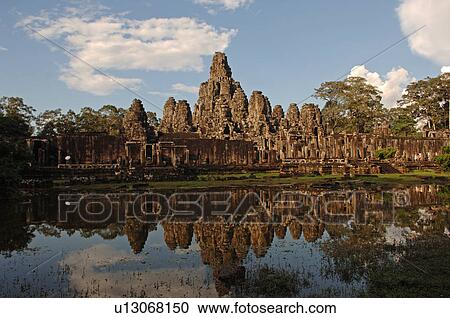 Stock Image - Exterior wall of Khmer Kingdom palace ruins reflected in pond. Fotosearch