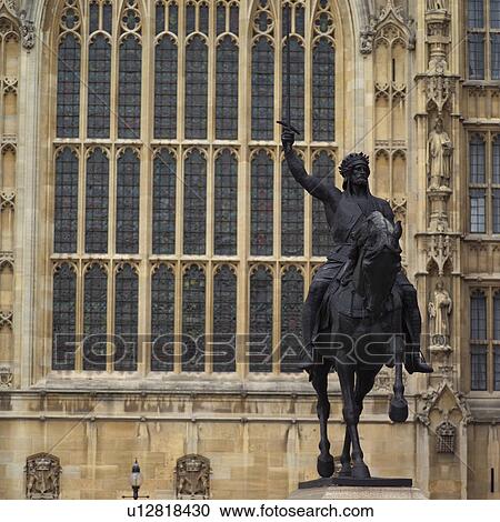 Stock Image - Edifice of an ancient historical building with a statue in front in London, England. Fotosearch
