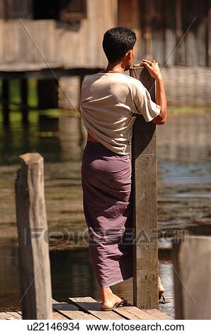 Picture - Back view of a man standing on dock. Fotosearch