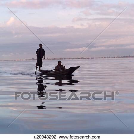 Stock Image - Intha fisherman in his flat-bottomed boat. Fotosearch