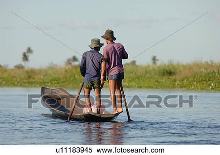 Stock Photography - Men standing in row boat. Fotosearch