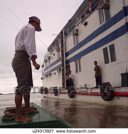 Stock Photo - Men standing on a boat on Ayevanwady River. Fotosearch