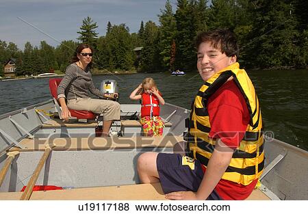 Stock Photo - Mother with her son and daughter in a motor boat. Fotosearch