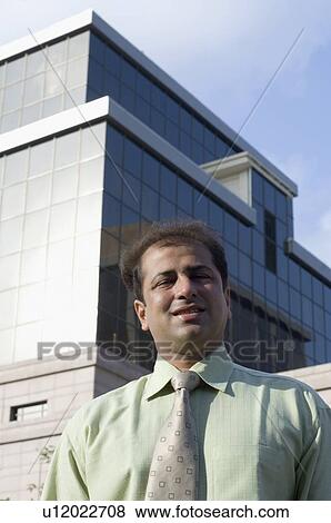 Stock Photo - Businessman standing in front of a building. Fotosearch