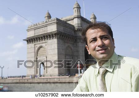 Close-up of a businessman smiling with monument in the background, Gateway of India, Mumbai, Maharashtra, India View Large Photo Image Stock Image - Close-up of a businessman smiling with monument in the background, Gateway of India, Mumbai, Maharashtra, India. Fotosearch
