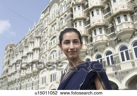 Portrait of a young woman smiling with a hotel in the background, Taj Mahal Palace & Tower, Colaba, India View Large Photo Image Stock Image - Portrait of a young woman smiling with a hotel in the background, Taj Mahal Palace & Tower, Colaba, India . Fotosearch
