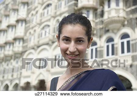 Portrait of a young woman smiling with a hotel in the background, Taj Mahal Palace & Tower, Colaba, India View Large Photo Image Stock Photo - Portrait of a young woman smiling with a hotel in the background, Taj Mahal Palace & Tower, Colaba, India . Fotosearch