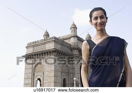 Portrait of a young woman standing a monument in the background, Gateway Of India, Mumbai, Maharashtra, India View Large Photo Image Stock Photo - Portrait of a young woman standing a monument in the background, Gateway Of India, Mumbai, Maharashtra, India. Fotosearch