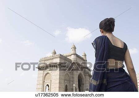 Rear view of a young woman standing with a monument in the background, Gateway Of India, Mumbai, Maharashtra, India View Large Photo Image Stock Photography - Rear view of a young woman standing with a monument in the background, Gateway Of India, Mumbai, Maharashtra, India. Fotosearch