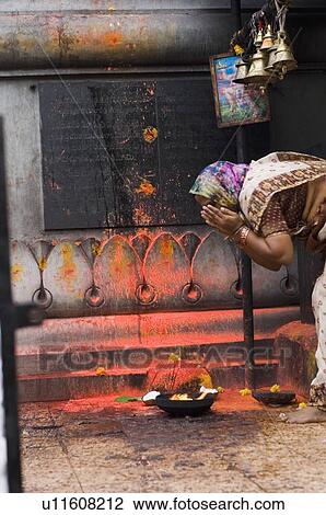 Stock Image - Side profile of a woman praying in a temple, Tirupati, Tirumala Venkateswara Temple, Tirumala, Andhra Pradesh, India. Fotosearch