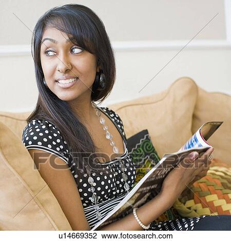 Close-up of a teenage girl sitting on a couch and holding a magazine View Large Photo Image Stock Image - Close-up of a teenage girl sitting on a couch and holding a magazine. Fotosearch