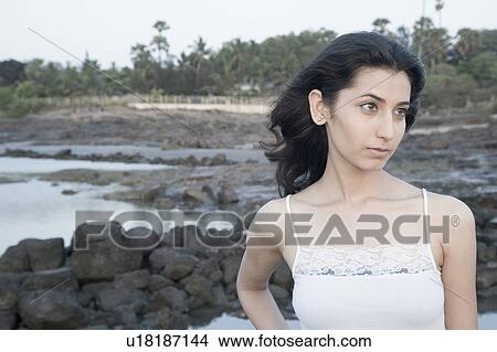 Close-up of a young woman standing on the beach View Large Photo Image Picture - Close-up of a young woman standing on the beach. Fotosearch