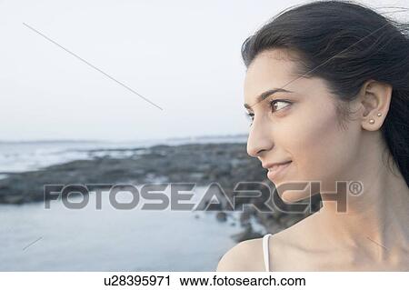 Close-up of a young woman thinking on the beach View Large Photo Image Stock Image - Close-up of a young woman thinking on the beach. Fotosearch