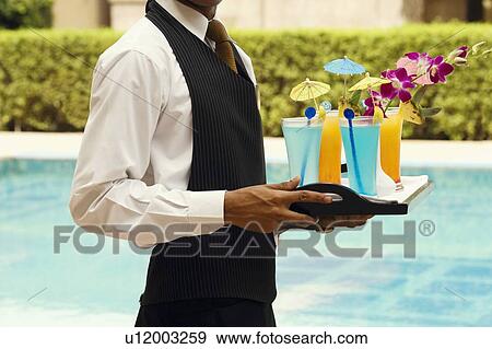 Mid section view of a waiter holding a tray of drinks View Large Photo Image Stock Photo - Mid section view of a waiter holding a tray of drinks. Fotosearch