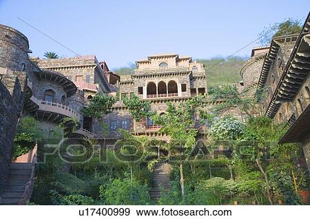 Stock Photo - Trees in front of a fort, Neemrana Fort Palace, Neemrana, Alwar, Rajasthan, India. Fotosearch