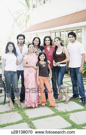 Mature woman standing with her daughters and her guests in front of a building View Large Photo Image Stock Image - Mature woman standing with her daughters and her guests in front of a building. Fotosearch