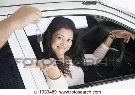 Stock Photo - Person's hand handing over a car key to a young woman. Fotosearch