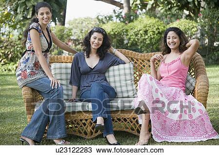 Portrait of three young women sitting in a lawn and smiling View Large Photo Image Stock Image - Portrait of three young women sitting in a lawn and smiling. Fotosearch
