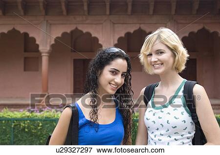 Stock Photo - Portrait of two young women smiling, Taj Mahal, Agra, Uttar Pradesh, India. Fotosearch