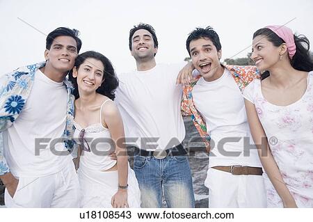 Stock Image - Three young men and two young women standing together and smiling. Fotosearch