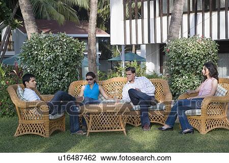 Two young couples sitting in a lawn View Large Photo Image Stock Image - Two young couples sitting in a lawn. Fotosearch