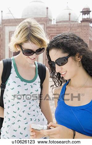 Two young women looking at a digital camera, Taj Mahal, Agra, Uttar Pradesh, India View Large Photo Image Stock Image - Two young women looking at a digital camera, Taj Mahal, Agra, Uttar Pradesh, India. Fotosearch