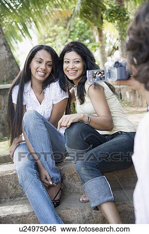 Woman filming two young women with a digital video camera View Large Photo Image Stock Photograph - Woman filming two young women with a digital video camera. Fotosearch