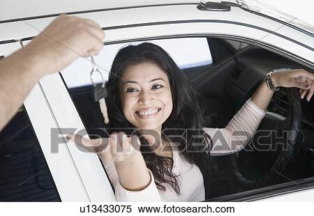 Young woman taking a car key and smiling View Large Photo Image Stock Photography - Young woman taking a car key and smiling. Fotosearch